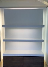 Espositore da parete retroilluminato con mensole e cassettone doppio