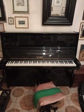 Pianoforte verticale Petrof nero con  panca , usato come complemento d’arredo.