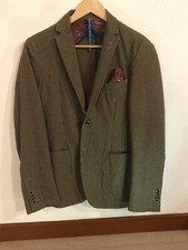 Giacca motivo pied-de-poule, fodera interna in fantasia con pochette abbinata.