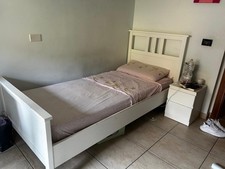 Letto singolo con materasso  e comodino  bianchi.