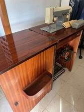 Macchina da cucire Necchi vintage inserita nel suo mobiletto di legno marrone.