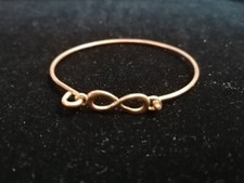 BRACCIALE RIGIDO SIMBOLO INFINITO, METALLO COLOR ORO, originale, diam 6cm