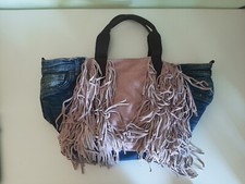 Borsa in pelle e jeans a mano