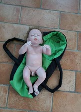 Bambolotto  Realistico Reborn con Navetta Verde . Cappelli Castano Occhi Chiusi