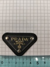 Targhetta Prada triangolo, Nero Oro, Con Vetro In Plastica E Simil Pelle