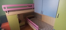 Cameretta a ponte usata ad angolo con 2 letti, comodino e scaletta.