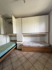 camera: due letti con contenitore, armadio bianco e mobile bianco