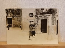 donne portano sulla testa sacchi asino davanti chiesa insegna poste italiane '50