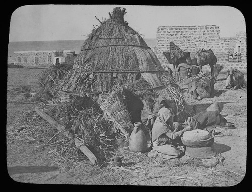 Woment outside straw tent - outside,