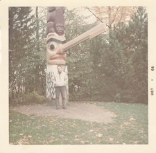 Foto d'epoca anni 60 a colori uomo di grande totem nel parco forestale