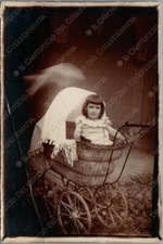 Bambina in antica carrozzina passeggino Fotografia