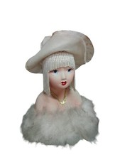 Busto decorativo di bambola vintage con cappello e boa di piume.