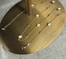 collana perla coltivata nell'acqua dolce; braccialetto dorato con perla 