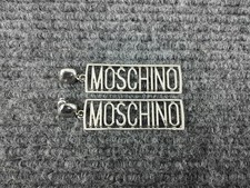 Orecchini pendenti tono argento con logo Moschino 
