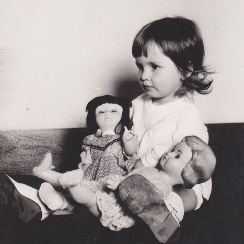 Bambina che tiene due bambole