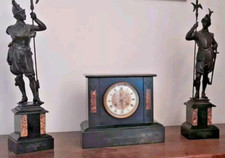 Antico orologio da tavolo con due statue.