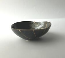 Ciotola nera elegante, ceramica giapponese rotta e riparata con l'arte Kintsugi.