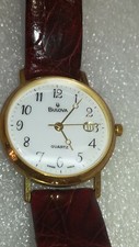 Bulova al quarzo in oro 18k con datario e cinturino bordeaux in pelle.