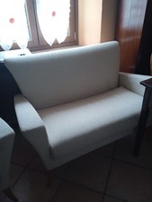 divano e poltrona uguali di tessuto bianco panna . Con piedini in legno